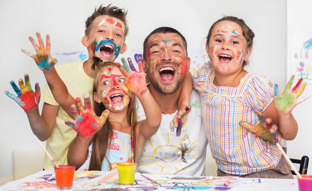 Children playing with paint with dad